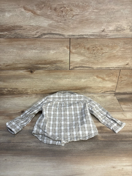 Plaid long sleeve toddler shirt in neutral colors on wood background