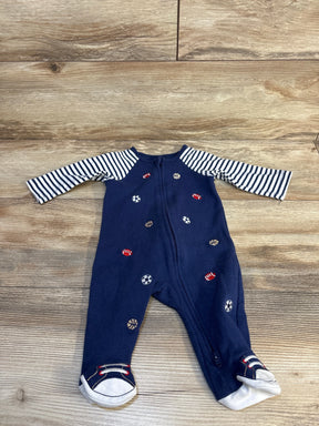 Navy baby onesie with sports ball print, striped sleeves, and sneaker feet, laid on wood floor