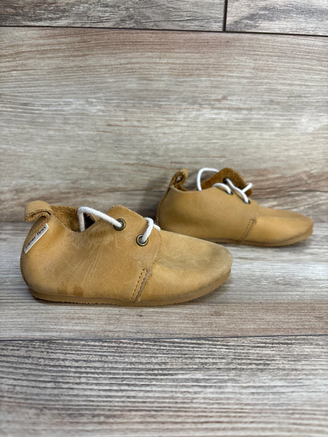 Side view of Piper Finn Natural tan low-top oxfords size 6C showing soft leather upper, white laces and light wear on wooden background