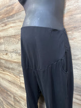 Side view of black maternity leggings showcasing high-rise waistband and side pocket with wood plank background