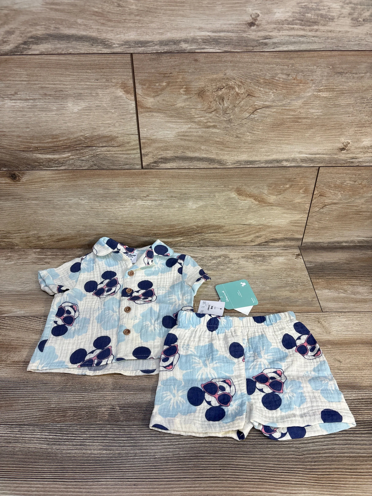 Baby Disney-themed short sleeve shirt and shorts set with Mickey Mouse sunglasses print on wood floor