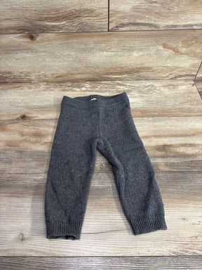 Gray knit baby pants laid flat on a wooden surface, soft warm fabric for toddlers
