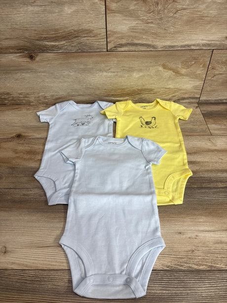 Flat lay of Carter's 3-pack short-sleeve bodysuits showing two white and one yellow with small animal chest prints on wood background