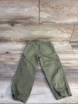 Flat lay back view of toddler green drawstring pants showing elastic waist, patch pocket and elastic cuffs on wood floor