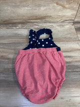 Top-down view of Carter's bubble romper showing navy star-print bodice with ruffled straps and red-and-white striped bubble bottom on wood floor