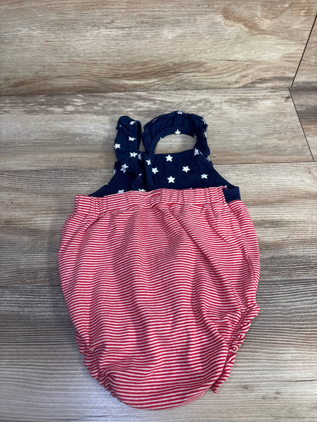 Top-down view of Carter's bubble romper showing navy star-print bodice with ruffled straps and red-and-white striped bubble bottom on wood floor