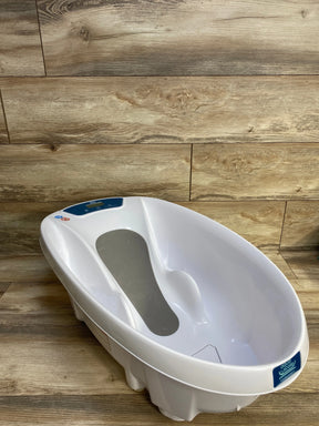 Angled three-quarter view of AquaScale infant tub showcasing digital scale display and gray non-slip seat with wood plank background