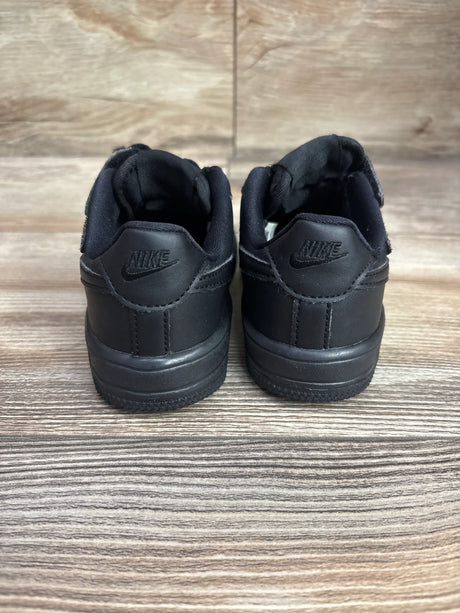 Rear view of Nike Force 1 Low EasyOn PS Triple Black sneakers showing padded collars on wood-grain flooring