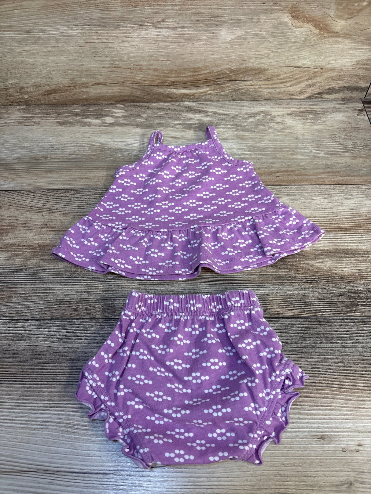 Purple baby girl ruffle tank top and bloomers set with white polka dot pattern on wood background