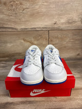 Front view of toddler Nike Dunk Low sneakers, white leather with hyper royal blue swooshes and blue soles, on red Nike box