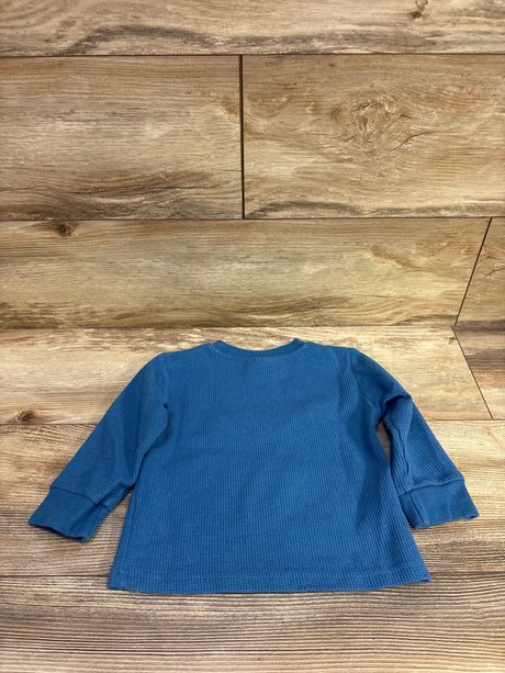 Back view of Marvel Spider-Man blue waffle knit shirt in size 2T showcasing ribbed cuffs with wood grain background