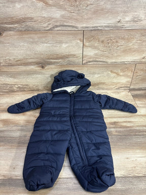 Navy blue puffer snowsuit for baby with hood and fleece lining, laid flat on wood floor