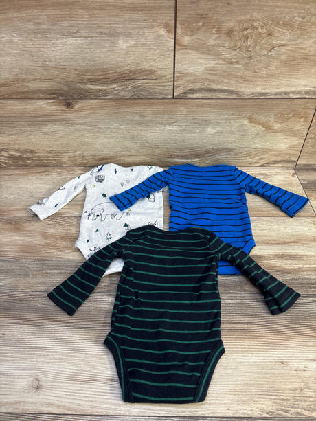 Flat lay of Carter's 3-pack long-sleeve bodysuits (3M) showcasing gray printed, blue striped, and navy green-striped designs on wooden background