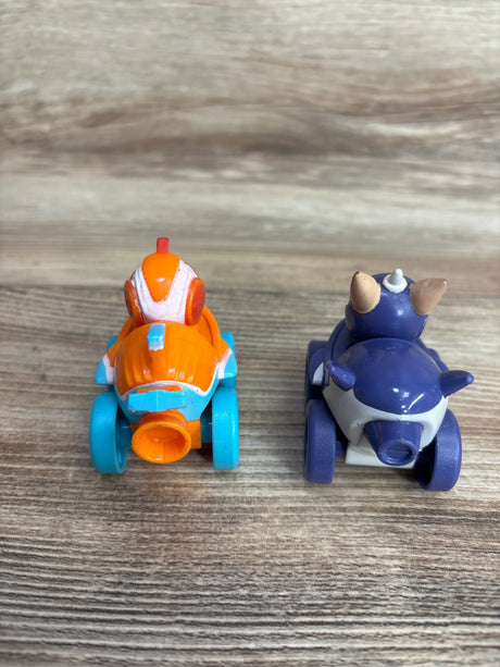 Rear view of two small colorful children's toy cars on wooden surface, one orange and blue, the other purple and white