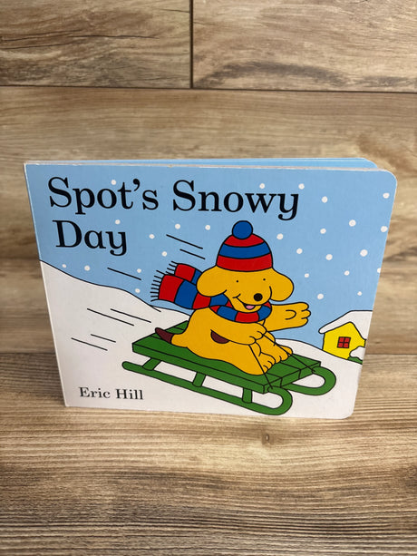 Children's board book Spot's Snowy Day by Eric Hill featuring a dog sledding in snow with winter hat and scarf