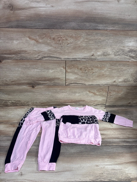 Top view of pink 2-piece leopard color block sweatshirt and joggers set showcasing black panels with a wood plank background