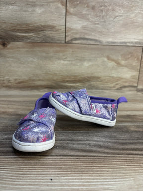 Purple glitter toddler shoes with star pattern, slip-on design, white soles on wood floor