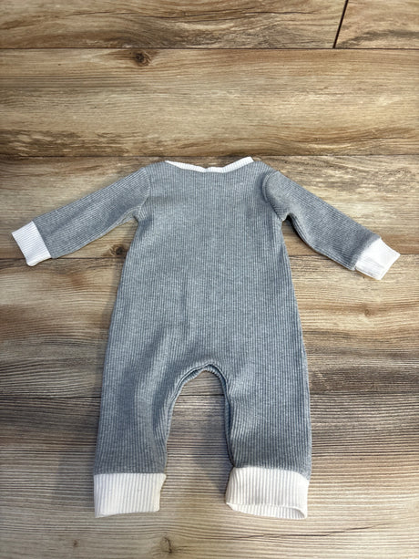 Gray ribbed baby romper with white cuffs on wooden background