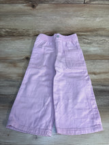 Light purple kids shorts with elastic waist and side pockets, laid on wood floor