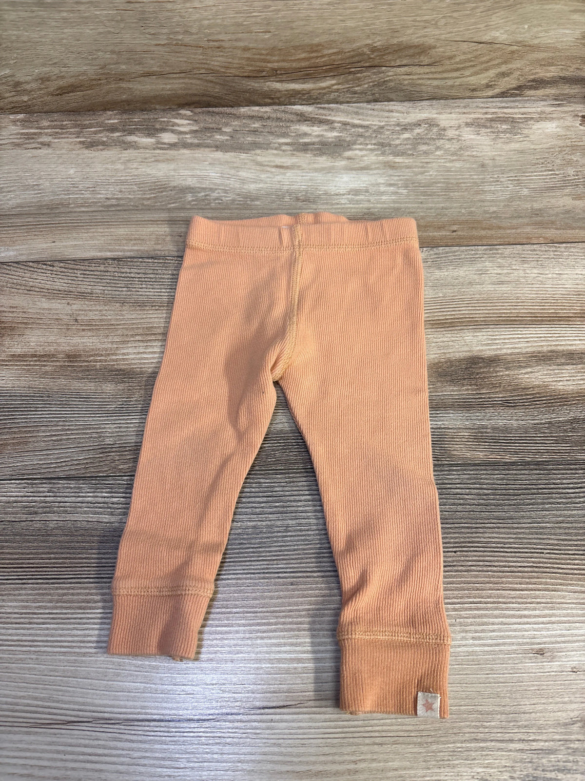 Zara ribbed leggings in orange for babies size 9-12m on a wooden surface
