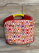 Front of B. Toys LapTrec drawing board showing red plastic top, yellow handle and colorful fabric cover on wood background