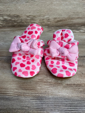 Front view of newborn pink cotton booties with heart print and bow trim on wood background, size 6-12 months