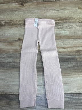 Light pink ribbed toddler leggings with elastic waistband on wood background