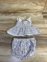 Flat lay of Nicole Miller smocked floral shirt and matching bloomers with ruffled straps and elasticized legs on wood floor