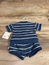 Flat-lay of Little Planet organic baby 2-piece set: navy and white striped short-sleeve top and matching shorts on wood floor