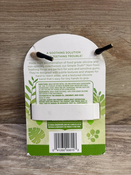 Back view of Simple Truth teal koala teething ring packaging showing A soothing solution to teething trouble on a wood surface