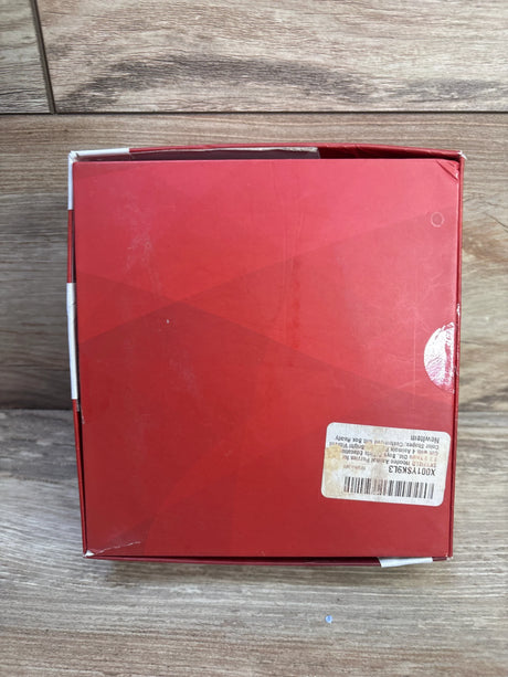 Top-down view of Skyfield 4pk wooden animal puzzles box showing red cardboard packaging and a peeling shipping sticker on a wood surface