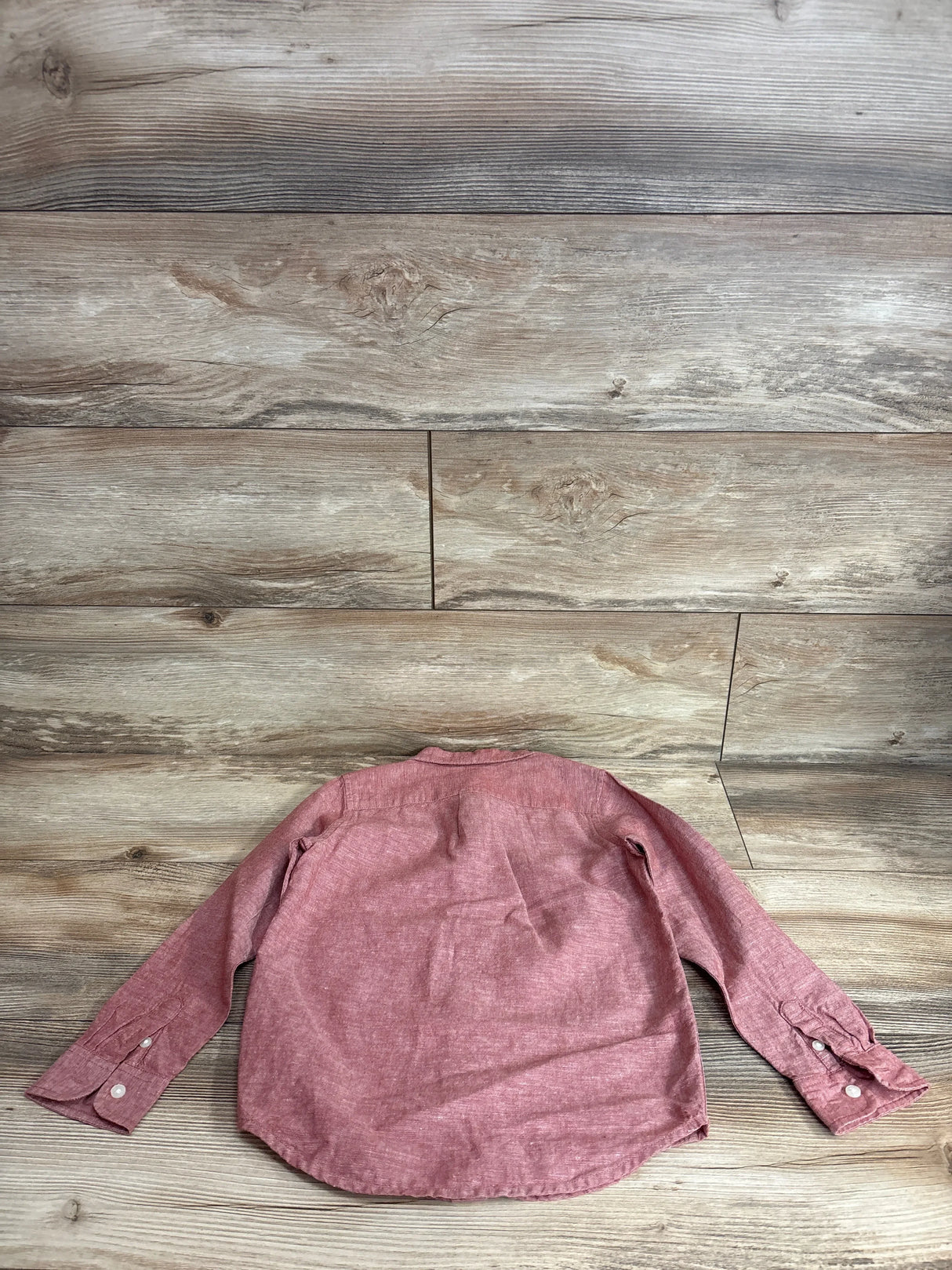 Back view of Janie and Jack red linen-cotton button-up shirt showing long sleeves and button cuffs on wood floor