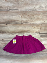 Top down view of Epic Threads purple toddler skirt size 5-6T showing elastic ruffled waistband and subtle textured diamond pattern on light wood floor