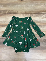 Front view of green Kyte Baby Bamboo Mistletoe Twirl Bodysuit Dress showcasing long sleeves and twirl skirt on wood