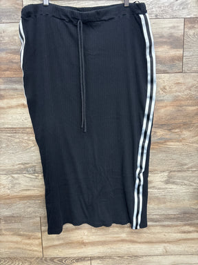 Black ribbed skirt with drawstring waist and white double side stripes on wooden floor