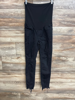 Front view of black SONG maternity full-panel distressed jeans showing high elastic belly panel, ripped knees and frayed ankle hems on wood background