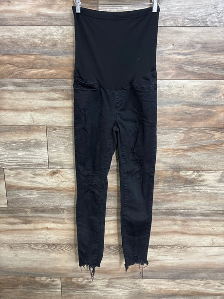 Front view of black SONG maternity full-panel distressed jeans showing high elastic belly panel, ripped knees and frayed ankle hems on wood background
