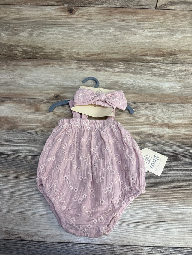 Flat lay front view of pink embroidered bubble romper with matching bow headband on hanger showing floral eyelet texture on wood background