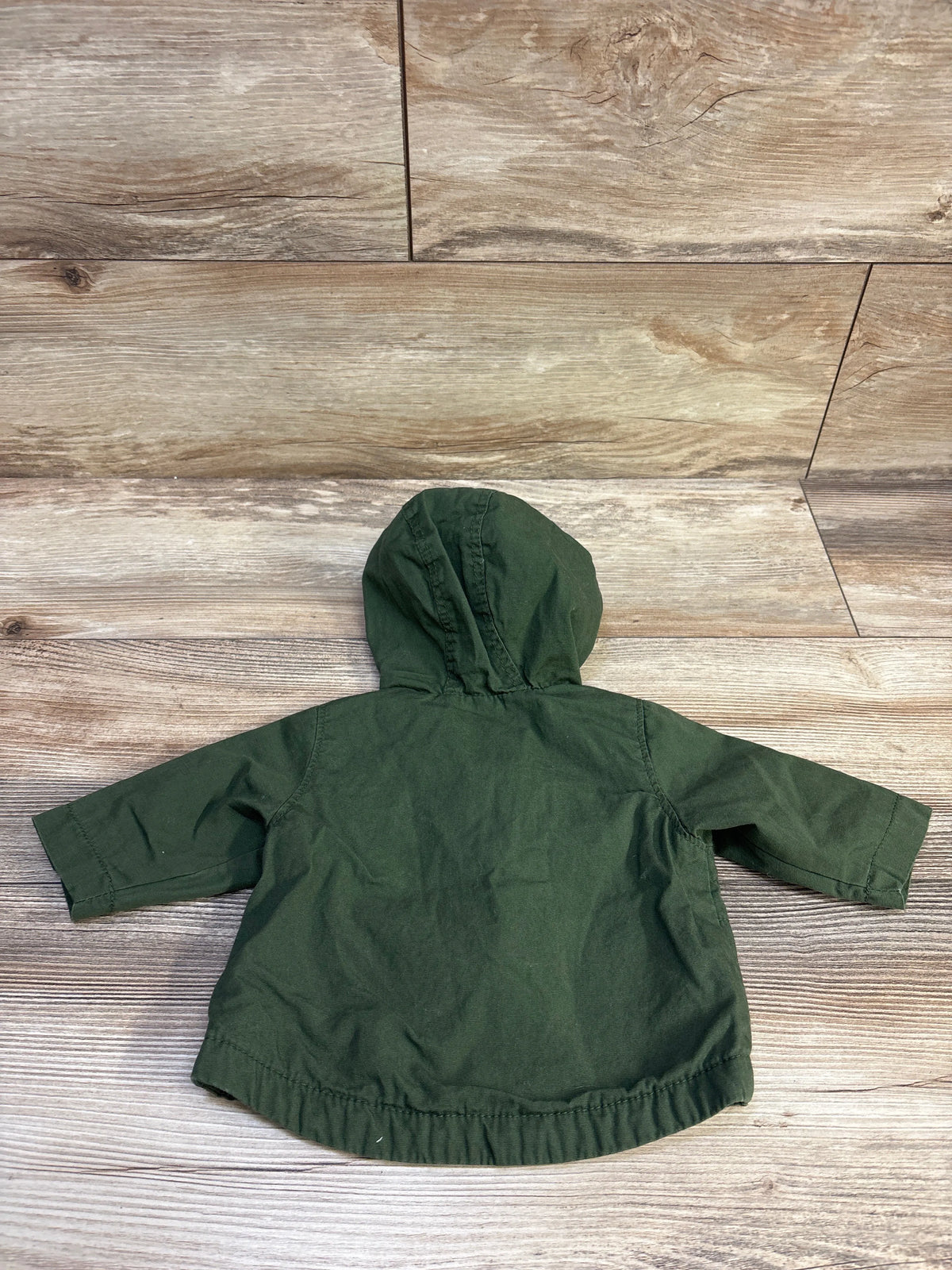 Back view of an Old Navy hooded utility jacket in green for infants size 0-3m on a wood background