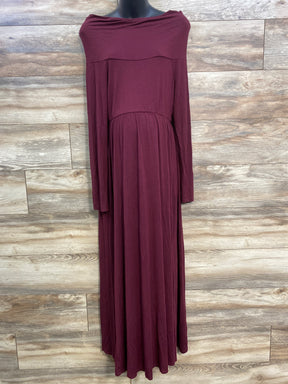 Long burgundy off-shoulder dress with long sleeves displayed on black mannequin against wood wall