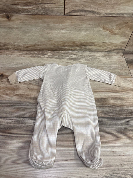 Front view of Carter’s beige striped footed sleeper with long sleeves on a wood surface