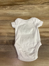 Front view of Nike white newborn bodysuit showcasing short sleeves and rounded neckline with a wood-grain background