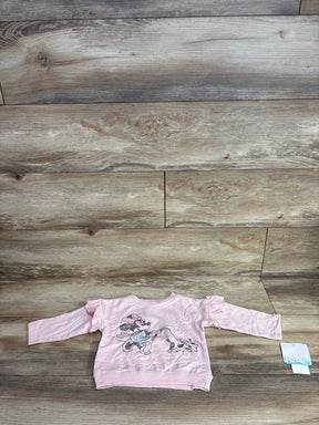 Pink long sleeve toddler shirt with cartoon character print, laid flat on wood floor
