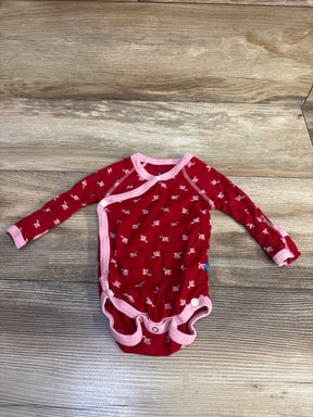 Front view of red long sleeve kimono bodysuit with pink trim and fish pattern on a wood-grain background
