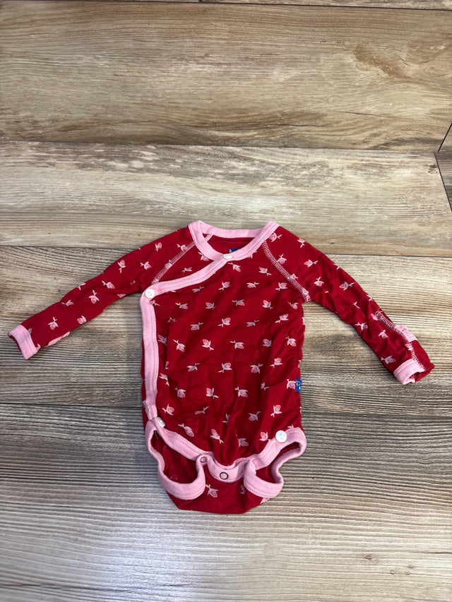 Front view of red long sleeve kimono bodysuit with pink trim and fish pattern on a wood-grain background