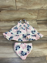 Flat lay of gauze baby dress and matching bloomers with pink and navy Minnie Mouse print on wood floor