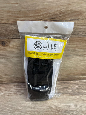 Front view of LILLEbaby waist belt extension strap in sealed packaging showing black strap and yellow label on wood surface