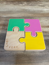 Colorful wooden toddler puzzle with four pieces on a wooden surface