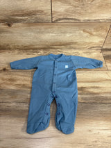 Blue long-sleeve baby onesie with snap buttons and feet, laid out on wooden floor