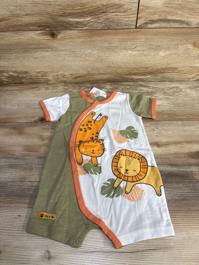 Flat lay of green and white baby shortie romper with orange trim, lion and leopard prints on wood floor background
